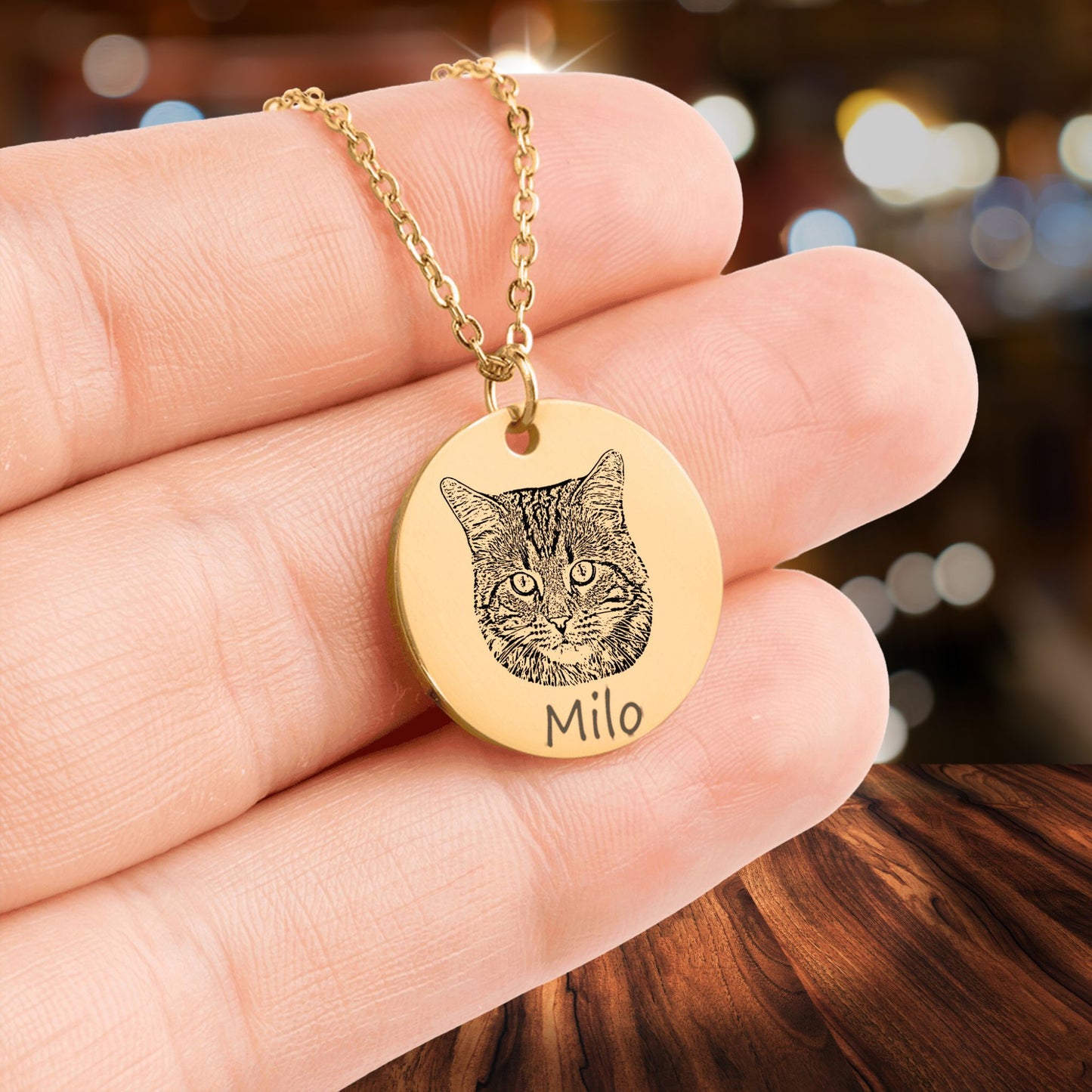 custom cat photo necklace in gold held in a hand
