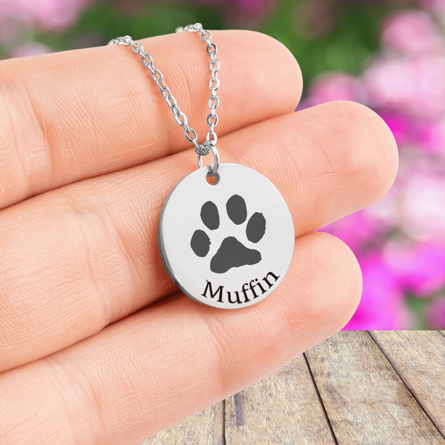 custom pet paw print necklace in silver held in a hand