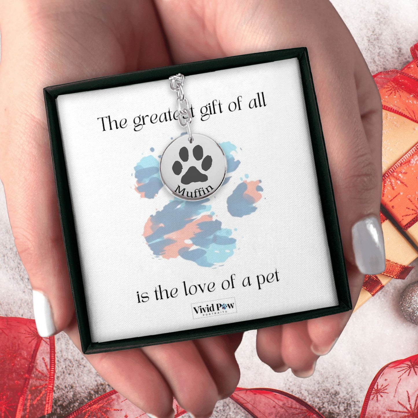 personalized paw print keychain in silver held in hands