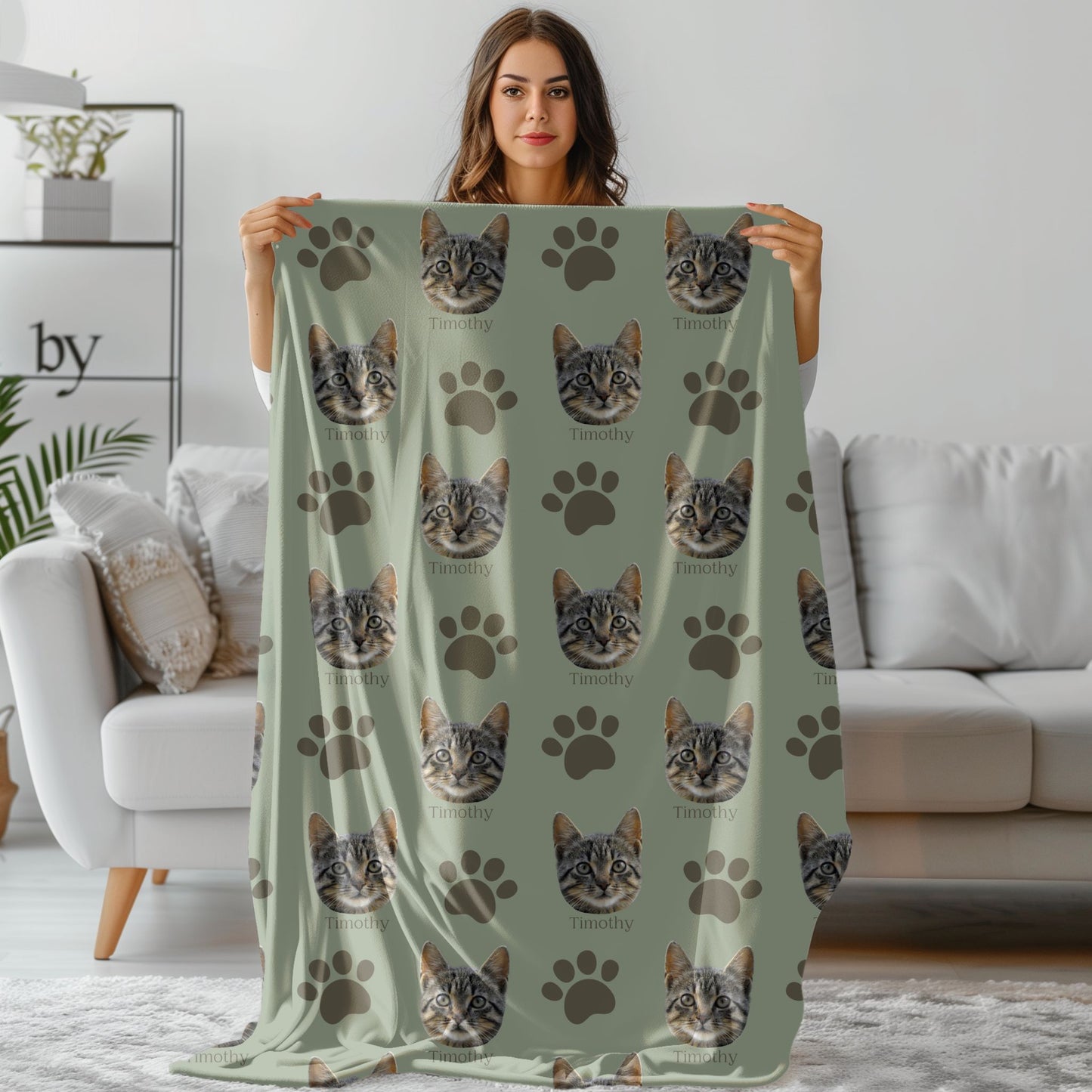 woman holding a personalized cat photo face blanket in sage/olive